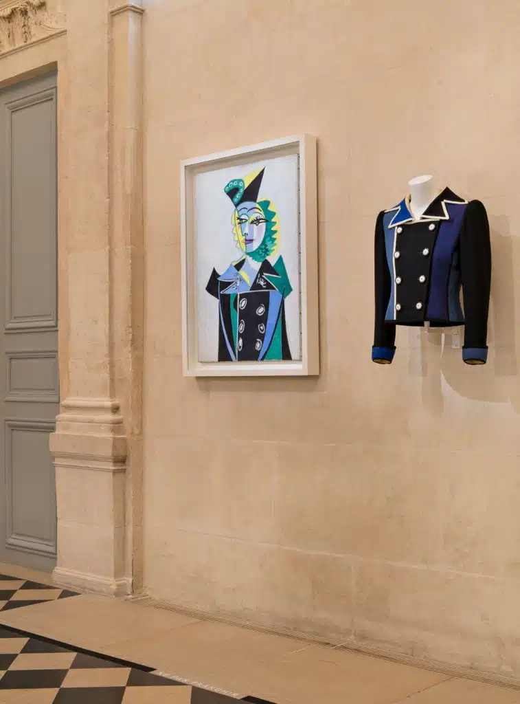 Vista da exposição 'Yves Saint Laurent aux musées', 2022, no Museu Nacional Picasso-Paris. ‘Retrato de Nusch Eluard’, 1937, Pablo Picasso ao lado de jaqueta YSL inspirada na pintura da coleção outono-inverno 1979. Foto: Nicolas Mathéus.