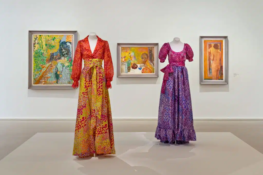 Vista de ‘Yves Saint Laurent aux musées’, 2022, no Museu de Arte Moderna de Paris. Três pinturas de Pierre Bonnard e dois vestidos YSL de 2001 inspirados no artista. Foto: Nicolas Mathéus.